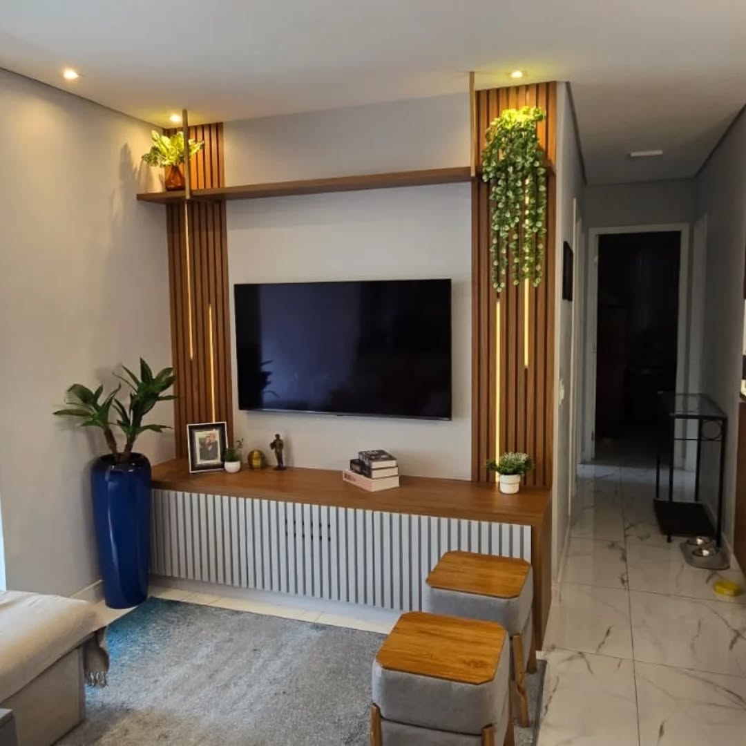 Sala de estar com painel planejado e estantes sob medida